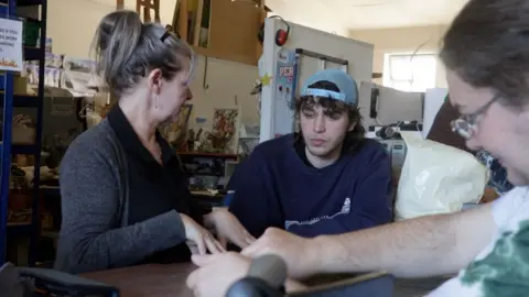 Volunteers and artists sat around a table during a pottery session in Chilli Studios