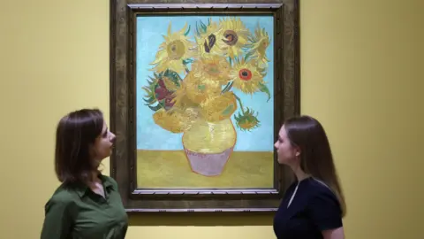 EPA Gallery workers view Dutch artist Vincent van Gogh's work titled 'Sunflowers' (1889) during a preview for the exhibition 'Van Gogh: Poets and Lovers' at the National Gallery in London, Britain, 09 September 2024