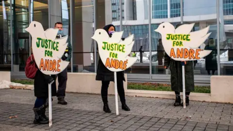 Protesters hold signs in the shape of doves saying "Justice for Andre" outside the Franklin County Common Pleas Courthouse in Ohio in 2021