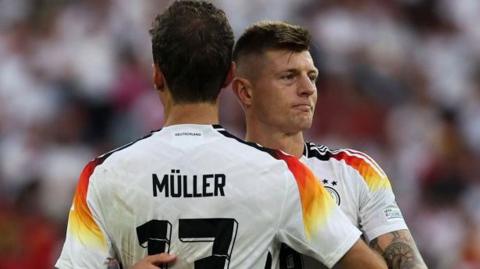 Thomas Muller consoles Toni Kroos after the loss to Spain