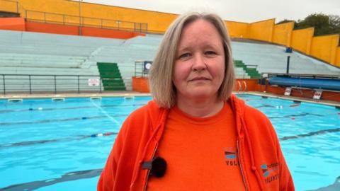 Emma Pusill stands in front of a pool