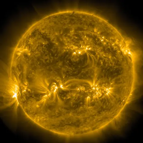 NASA Image of Sun from Nasa's Solar Dynamics Observatory, showing glowing gold and black patterns on the Sun's surface. 