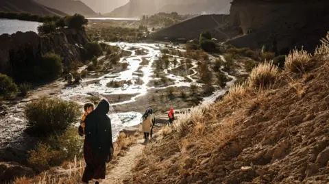 Getty Images Visitors walk through Band-e Amir National Park, a popular tourist attraction in Bamyan province near Yakawlang, Afghanistan, September 2022.