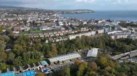 Manx Scenes Douglas from above, lines of houses and trees leading to the sea.