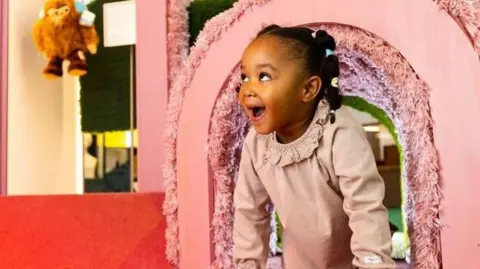 Young V&A A young girl looks excited as she emerges from a pink rainbow installation at the museum