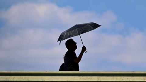 Person holding up an umbrella during a hot day