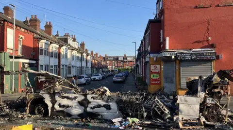 What's left of a public bus after it was set on fire and burnt badly. On a street in Harehills, all that is left is some of the bottom level of the vehicle. 