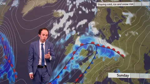 BBC weather presenter Calum MacColl in front of a weather map showing rain and snow.