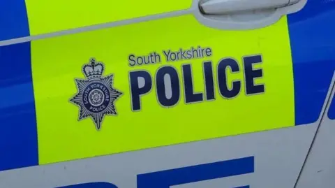 A picture of a door of police car with the words South Yorkshire Police written on. 