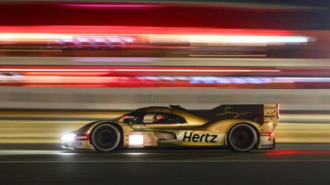 The Jota Porsche 963 driving at night at Le Mans