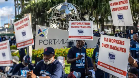 Workers protest outside of a port in Miami.