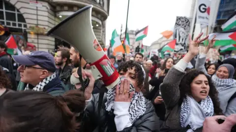 Pro-Palestinian demonstrators waving Palestinian flags march through Central London