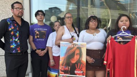 Family of Rebecca Contois hold up her photo outside a Winnipeg courthouse following Friday's verdict 