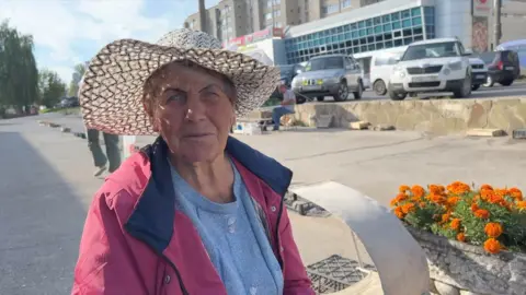 Lady standing by road with flowers