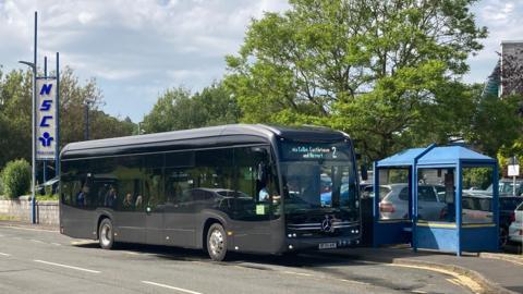 An electric bus outside the NSC on the Isle of Man