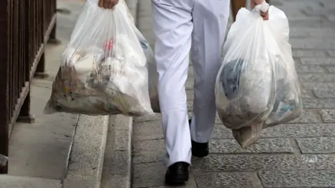 A man carrying rubbish bags 