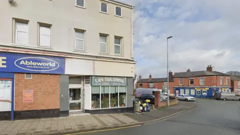 Google A street with a shop with a blue sign reading Ableworld in yellow writing