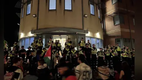 Police and protesters outside Cardiff Bay police station in June