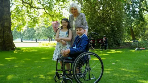 PA Media Tony Hudgell with Queen Camilla and Lyla O'Donovan