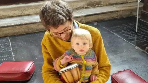 A father at a singing group with a child 