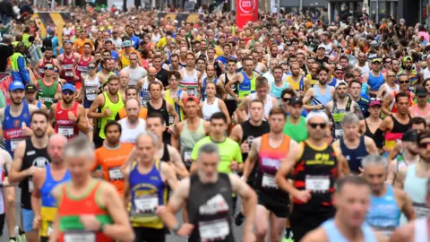 A crowd of runners at the 2023 Cardiff Half Marathon in various multicoloured vests and shorts