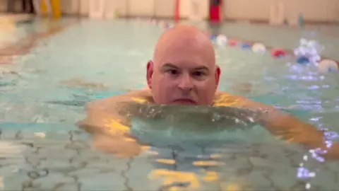 BBC Radio Leeds commentator James Deighton, swimming in a pool.