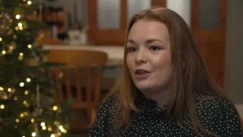 Woman with Christmas tree in backround