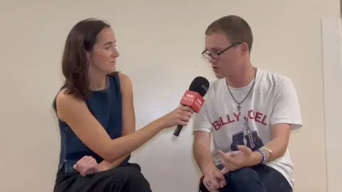 BBC journalist interviewing a male college student 