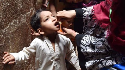 A health worker administers polio vaccine