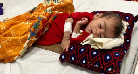 Child lying on bed in Afghan hospital