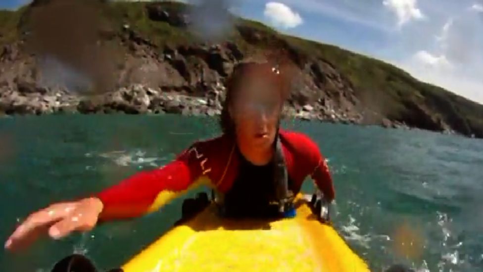 An RNLI lifeguard on a rescue board at Whitsand Bay