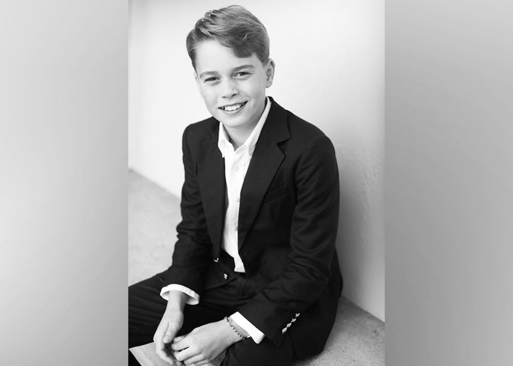 Black and white photo of Prince George in shirt and suit