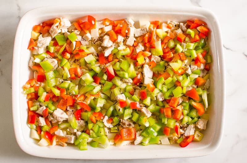 Chopped peppers and meat in casserole dish.