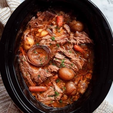 Crock pot sirloin tip roast with baby potatoes and carrots in gravy.