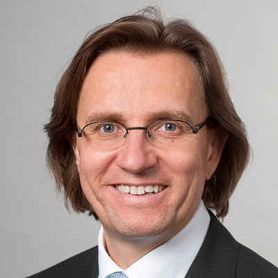 Headshot of Prof. Dr. Frank Martin Belz, a man of mature age smiling on a simple gray background.