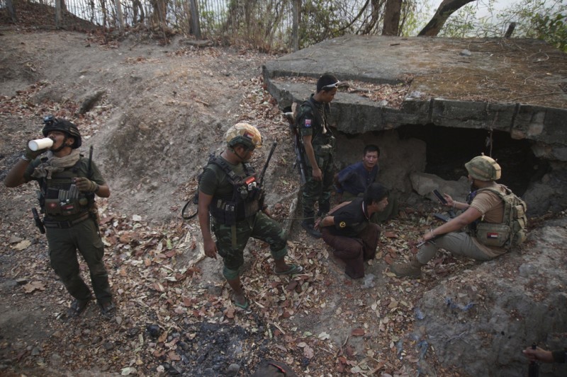 2024年3月11日。在緬甸克倫邦苗瓦迪鎮南部，克倫民族解放軍和人民國防軍成員在佔領一個軍隊前哨後對兩名被捕士兵進行檢查。（美聯社）