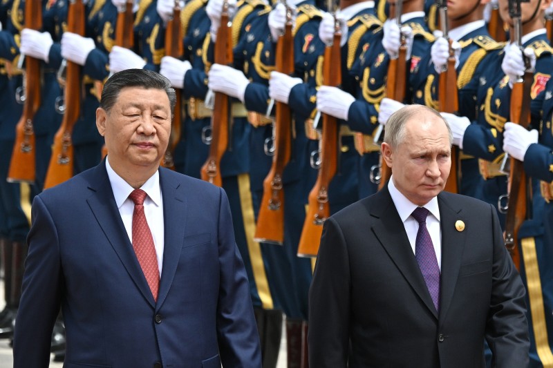 中國國家主席習近平在西方與俄羅斯之間，成了夾心餅乾。圖為習鳥近平和俄羅斯總統普京在歡迎儀式中檢閱儀仗隊。（美聯社）