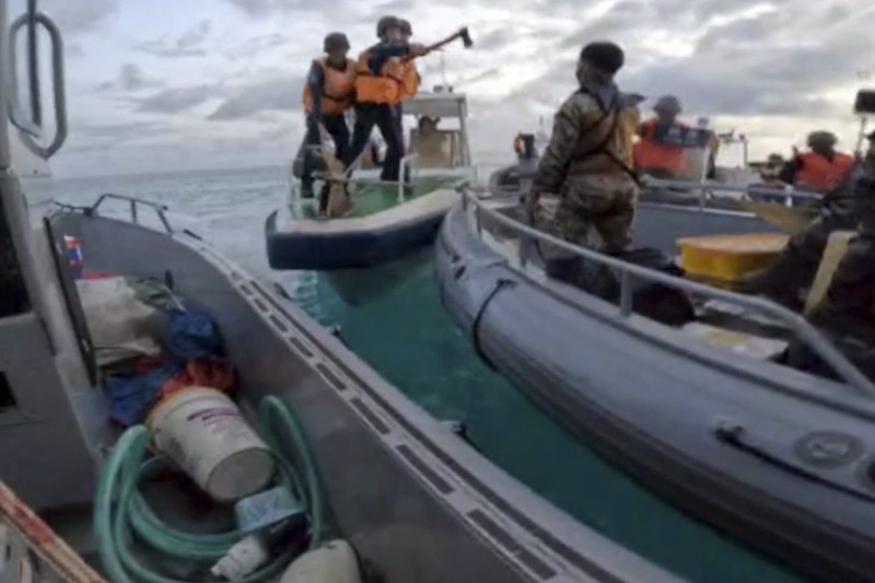 2024年6月17日，菲律賓政府的這張照片中，中國海警手持斧頭逼近執行補給任務的菲律賓軍隊。（美聯社）