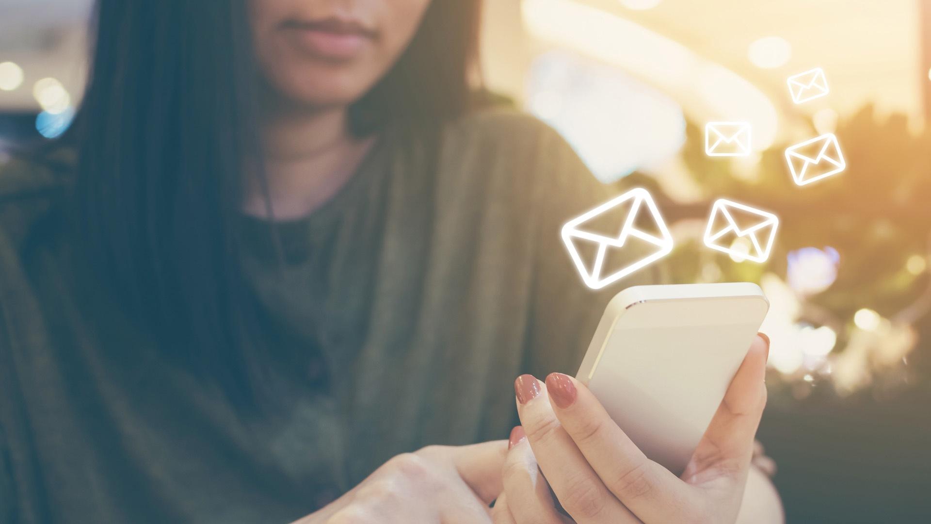 woman holding phone with mail icons surrounding it 