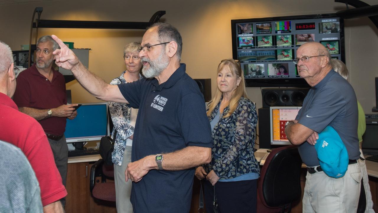 Volunteer leading a tour for the Classical 94.5 WNED Open House