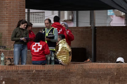 Miembros de la Cruz Roja asisten a una persona en el exterior del colegio Lluís Vives.