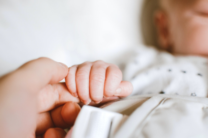 Madre cogiendo la mano de su bebé recién nacido