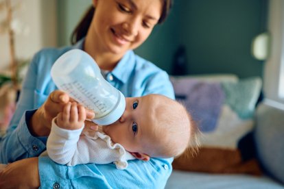 Una madre dando el biberón a un bebé