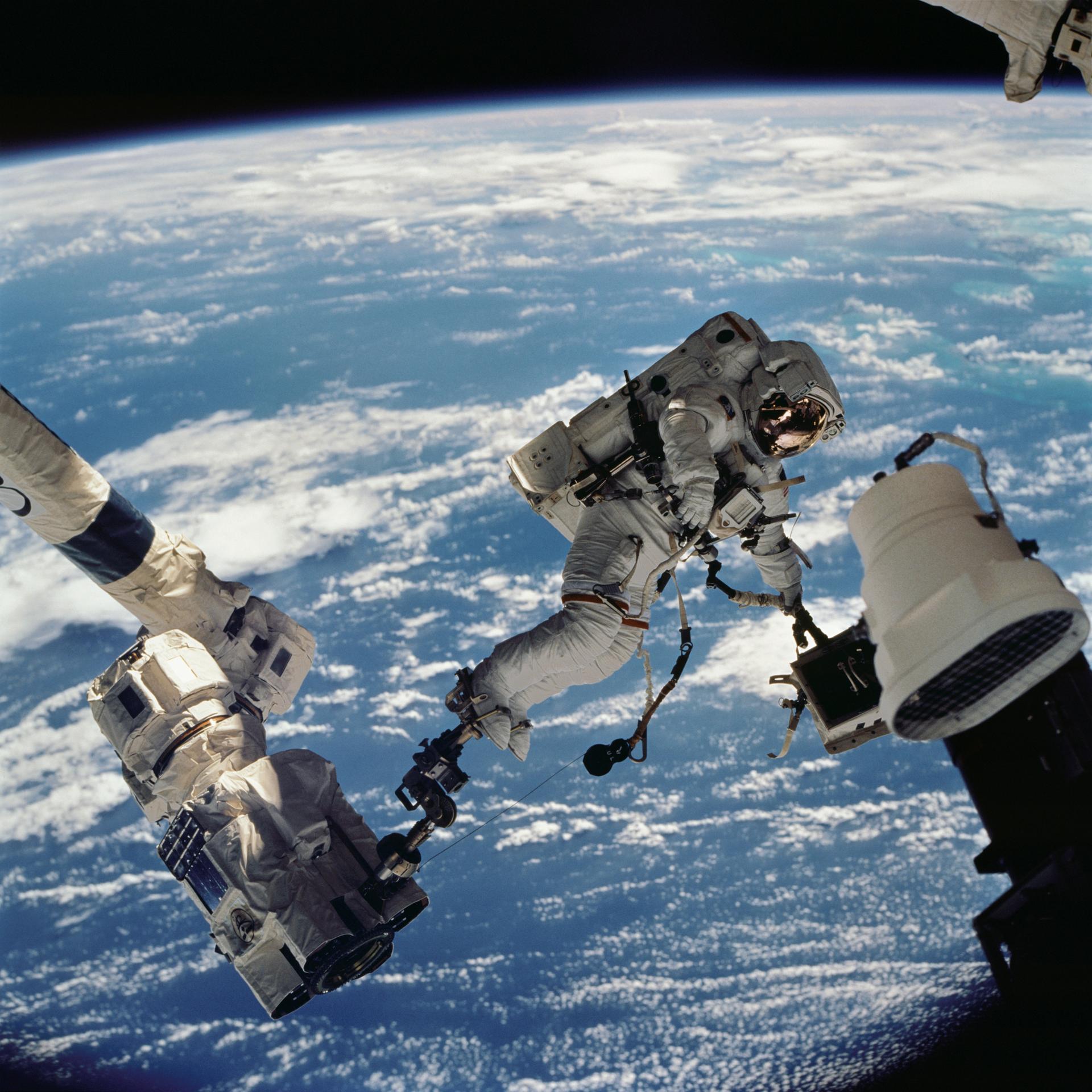 Anchored to a foot restraint on the Space Station Remote Manipulator System (SSRMS) or Canadarm2, astronaut David A. Wolf, STS-112 mission specialist, participates in the mission's first session of extravehicular activity (EVA). Wolf is carrying the Starboard One (S1) outboard nadir external camera which was installed on the end of the S1 Truss on the International Space Station (ISS). Launched October 7, 2002 aboard the Space Shuttle Orbiter Atlantis, the STS-112 mission lasted 11 days and performed three EVAs. Its primary mission was to install the S1 Integrated Truss Structure and Equipment Translation Aid (CETA) Cart to the ISS. The S1 truss provides structural support for the orbiting research facility's radiator panels, which use ammonia to cool the Station's complex power system. The S1 truss, attached to the S0 (S Zero) truss installed by the previous STS-110 mission, flows 637 pounds of anhydrous ammonia through three heat rejection radiators. The truss is 45-feet long, 15-feet wide, 10-feet tall, and weighs approximately 32,000 pounds. The CETA is the first of two human-powered carts that will ride along the International Space Station's railway providing a mobile work platform for future extravehicular activities by astronauts.