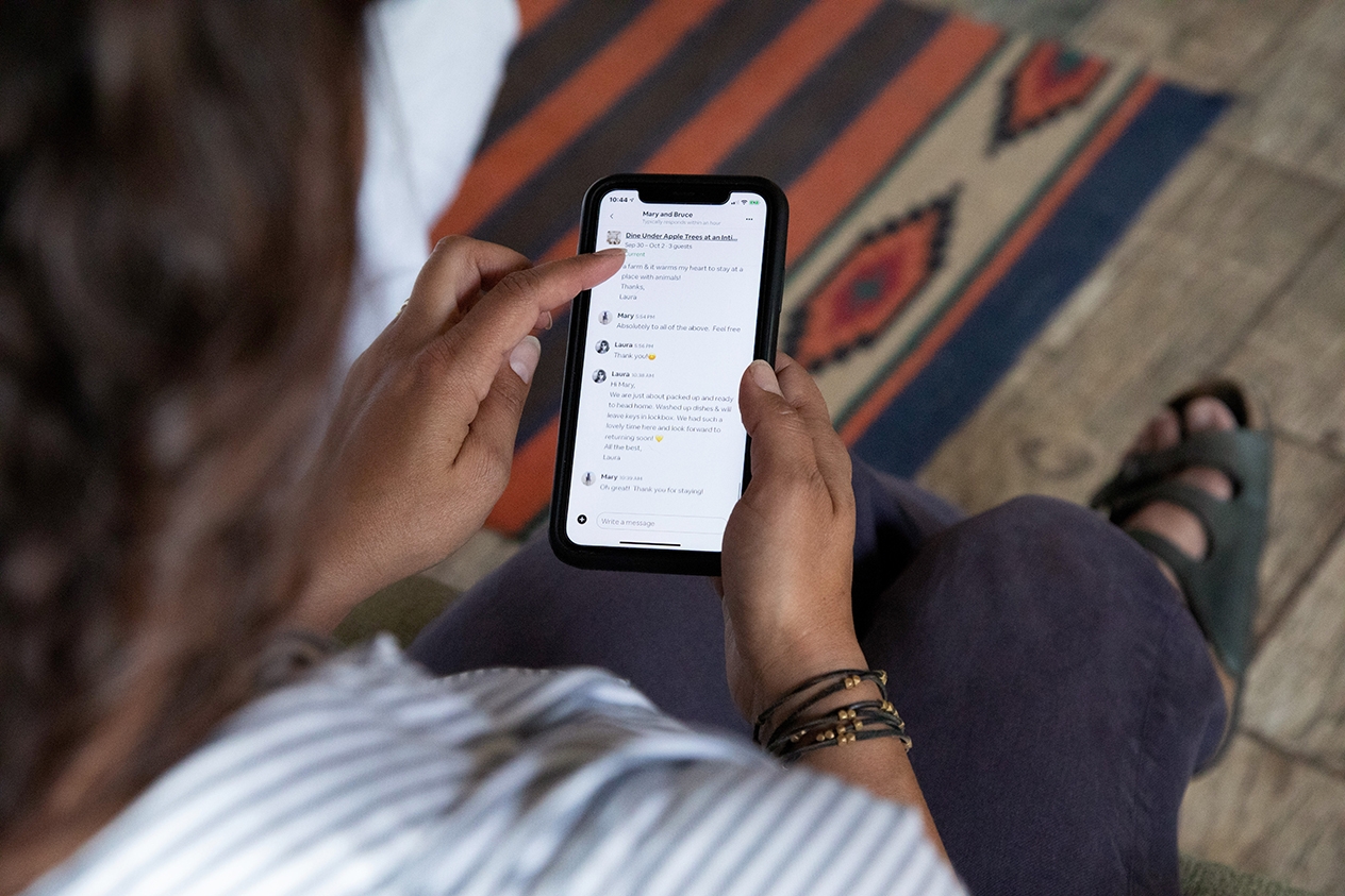 A person looking at the Airbnb app on their cell phone.