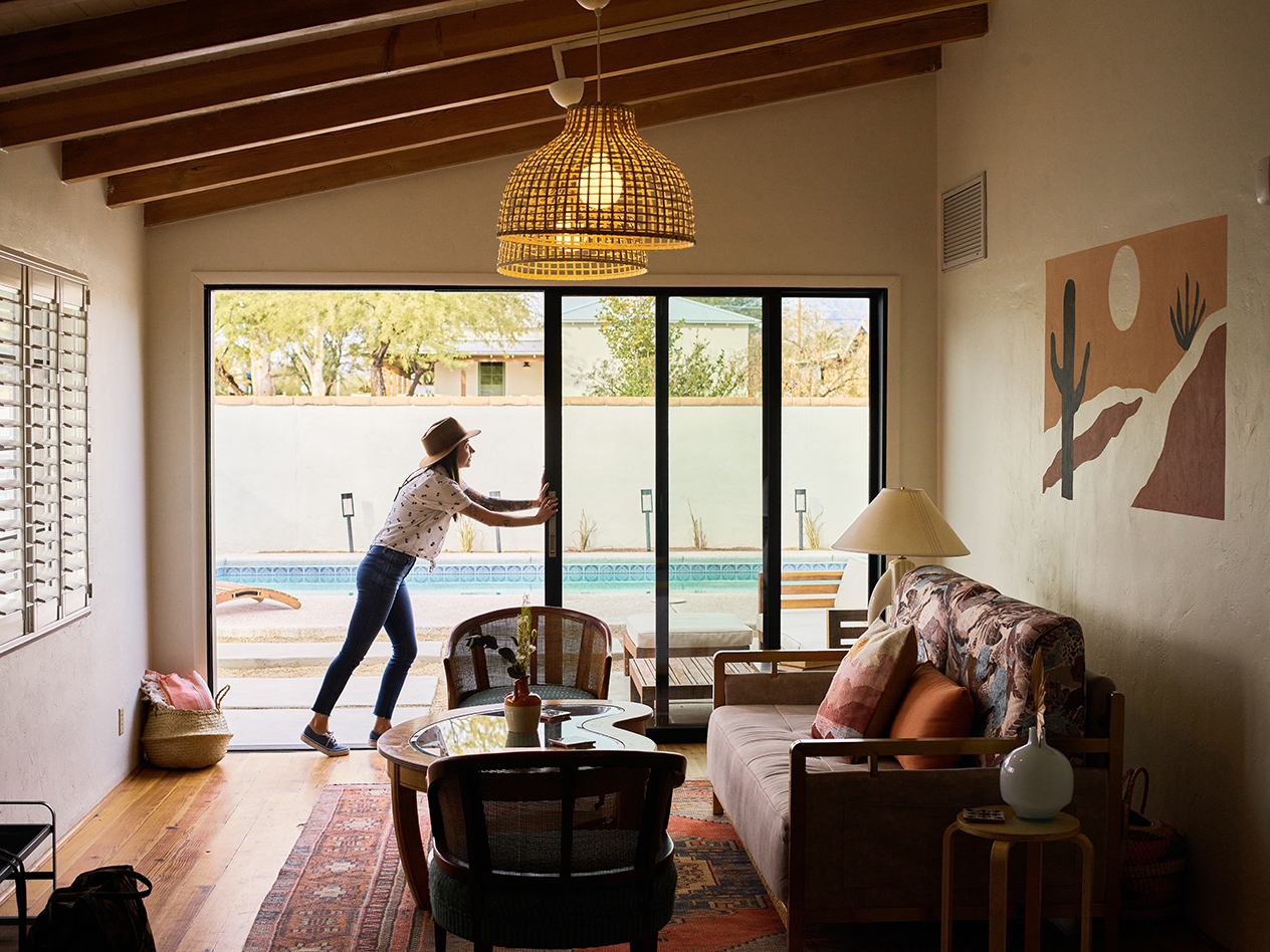 Person opening a glass sliding door in a nicely designed space