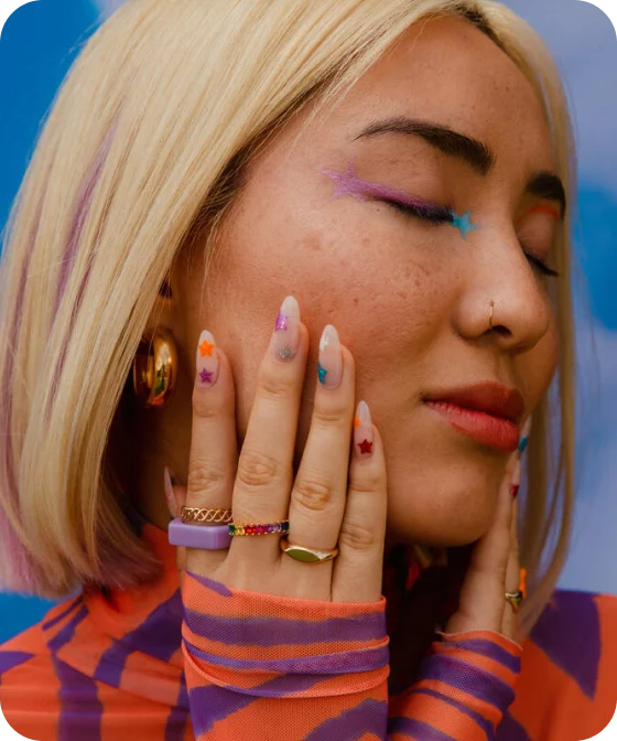 A woman wearing colorful nail art and makeup