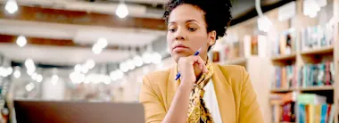 Woman studying in library with laptop