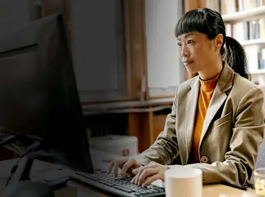 Librarian sitting in office working on laptop