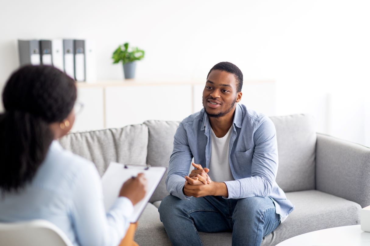 man sitting speaking to a therapist